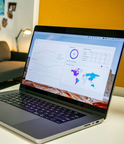Laptop and notebook on desk showing campaign reporting.